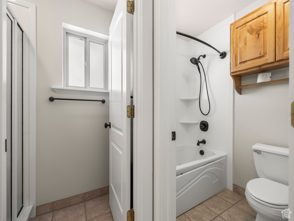 Full bath featuring toilet, shower / bath combination, baseboards, and tile patterned flooring