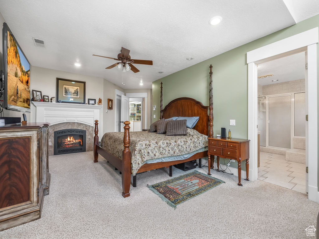 Carpeted bedroom with a lit fireplace, recessed lighting, and tile patterned floors