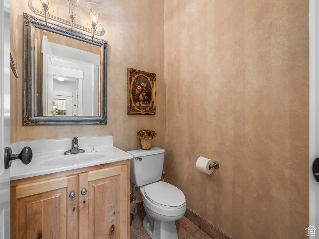 Bathroom with toilet, vanity, and tile patterned flooring