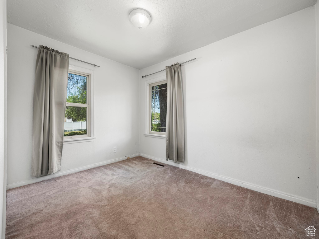 Empty room with carpet floors and baseboards