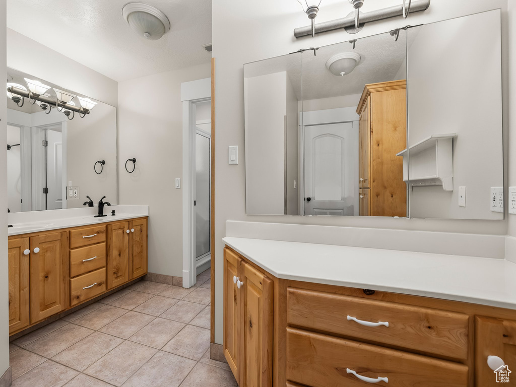 Full bath featuring tile patterned flooring, vanity, and baseboards