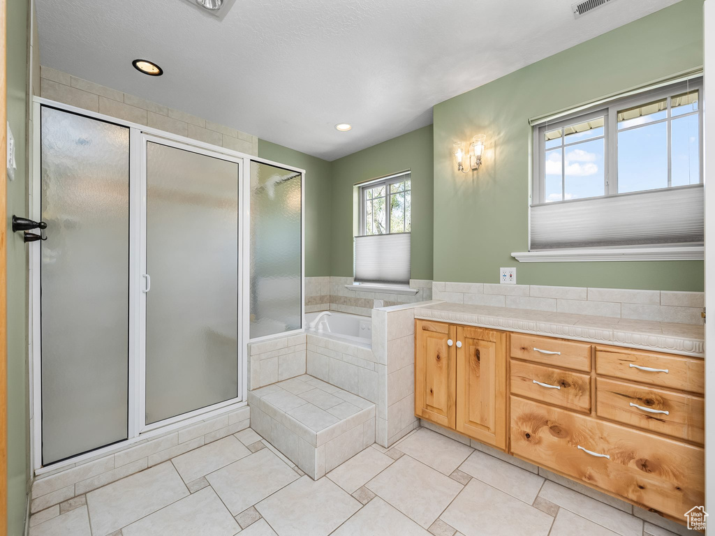 Full bathroom featuring a stall shower, a bath, tile patterned flooring, recessed lighting, and vanity