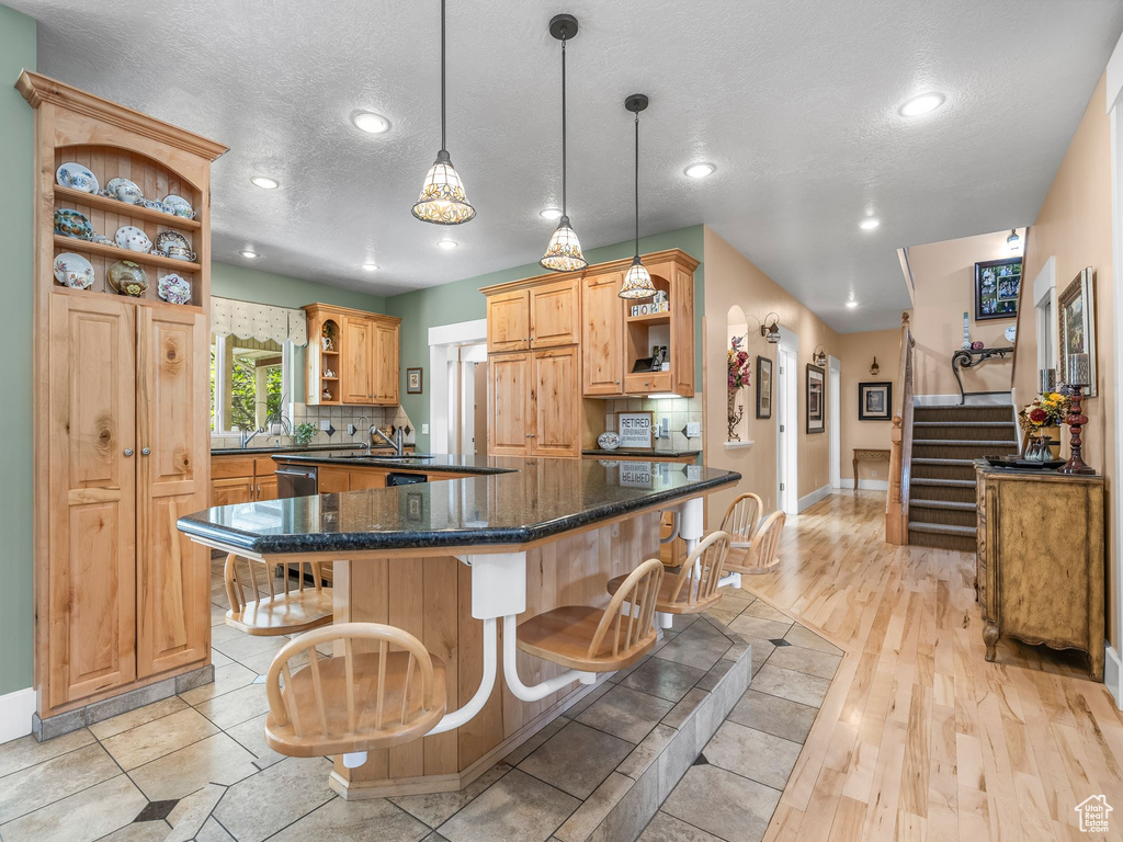 Kitchen featuring open shelves, a textured ceiling, baseboards, backsplash, and recessed lighting