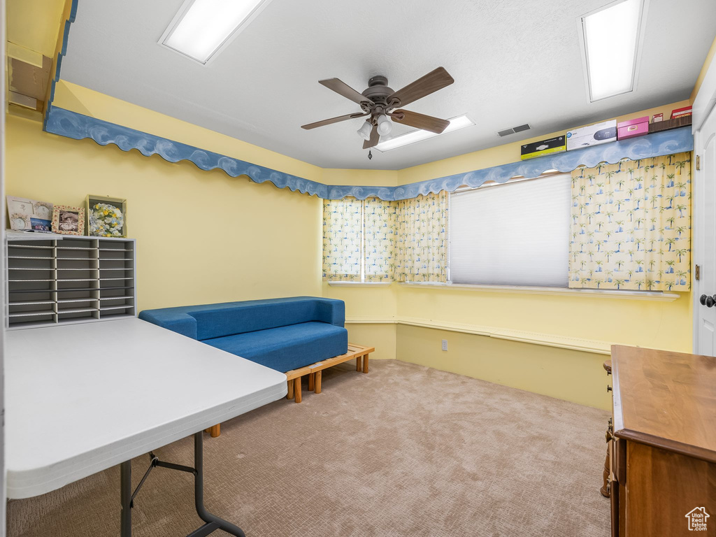 Living area with ceiling fan and carpet floors