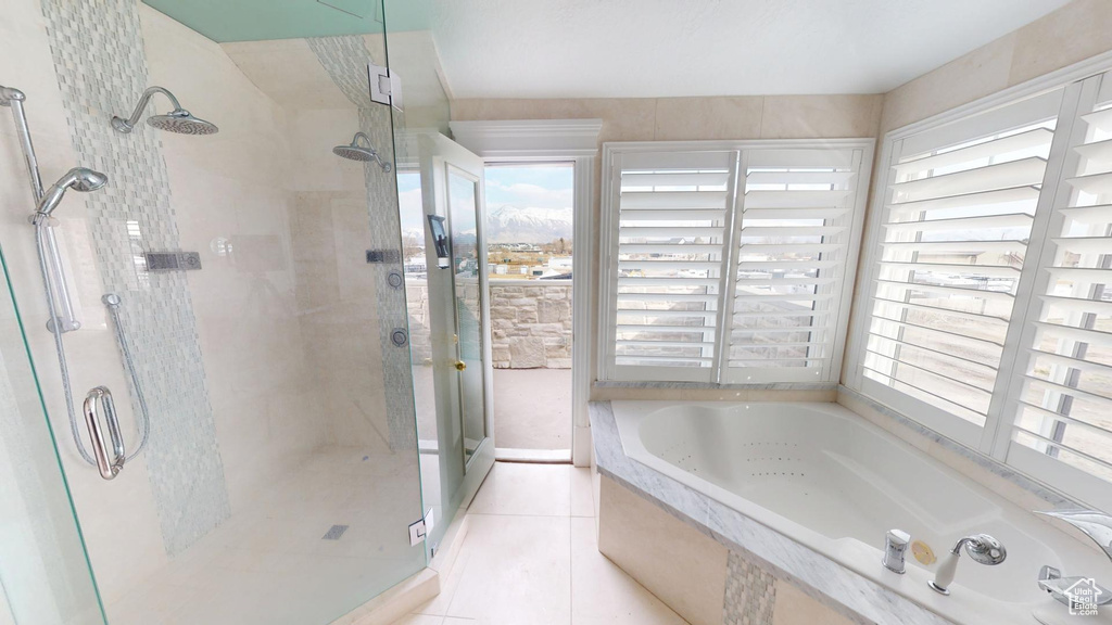 Full bath with a stall shower, plenty of natural light, and a bath