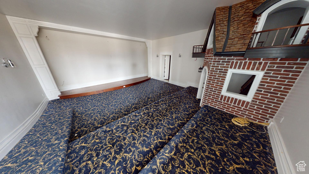Unfurnished living room featuring carpet floors and baseboards