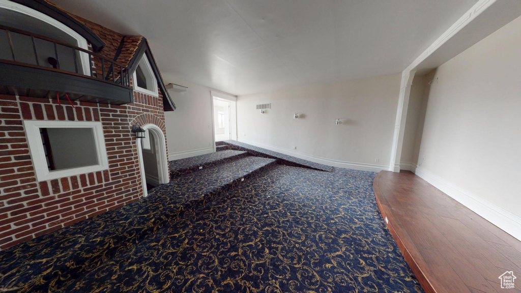 Unfurnished living room featuring wood finished floors and baseboards
