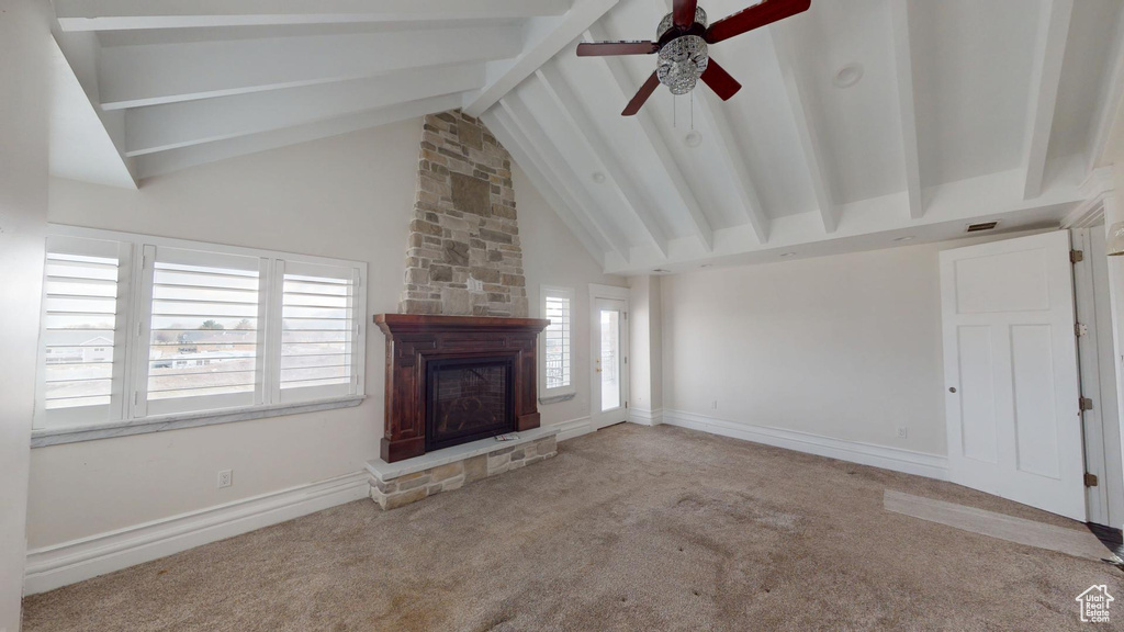 Unfurnished living room featuring high vaulted ceiling, carpet floors, a fireplace, baseboards, and beamed ceiling