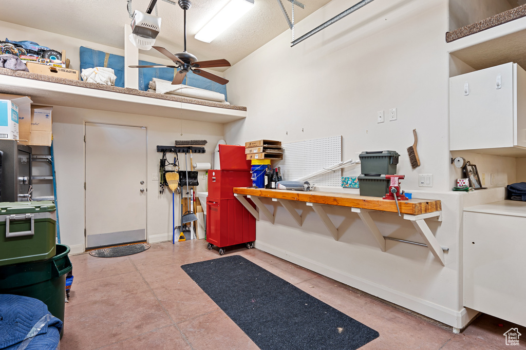 Garage with baseboards, a garage door opener, and a workshop area
