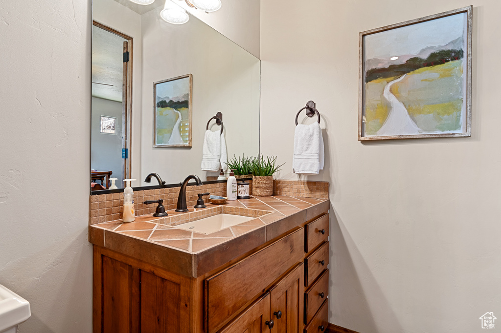 Bathroom with vanity and tasteful backsplash