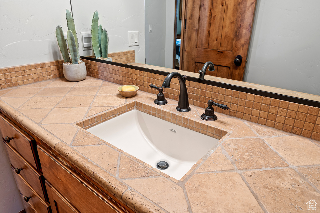 Bathroom featuring vanity and tasteful backsplash