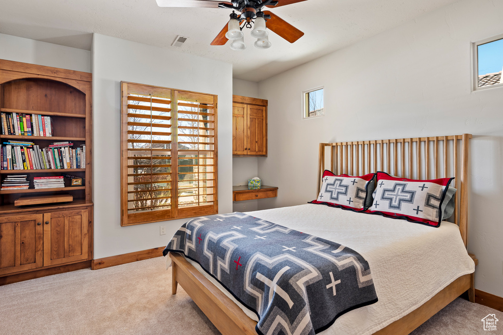 Carpeted bedroom with visible vents, baseboards, and multiple windows