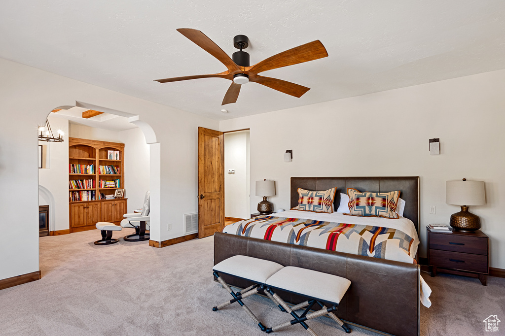 Bedroom featuring carpet floors, arched walkways, baseboards, and visible vents
