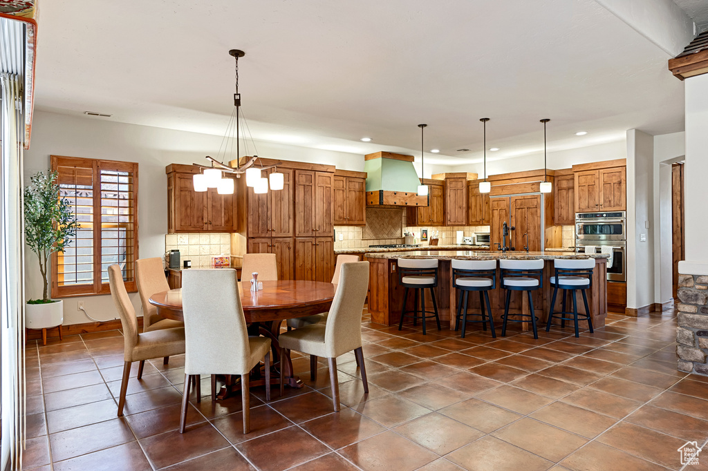 Dining area featuring recessed lighting, dark tile patterned floors, baseboards, and a chandelier