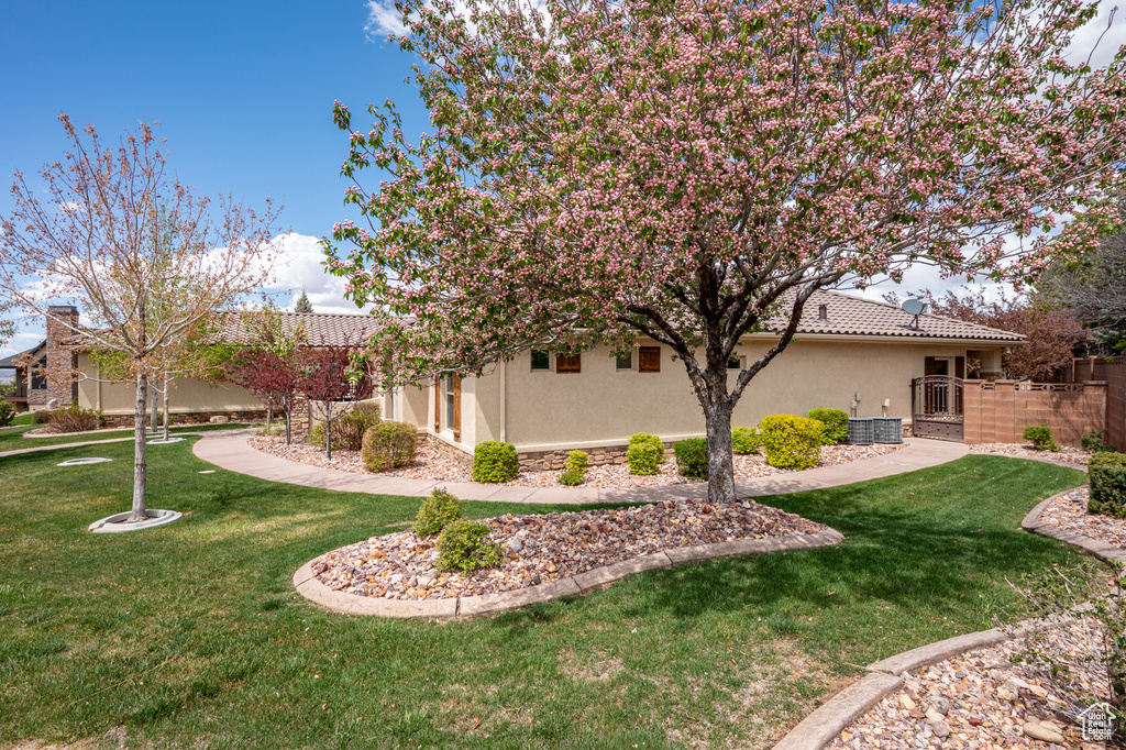 View of home\'s exterior with a lawn, a tiled roof, fence, and stucco siding