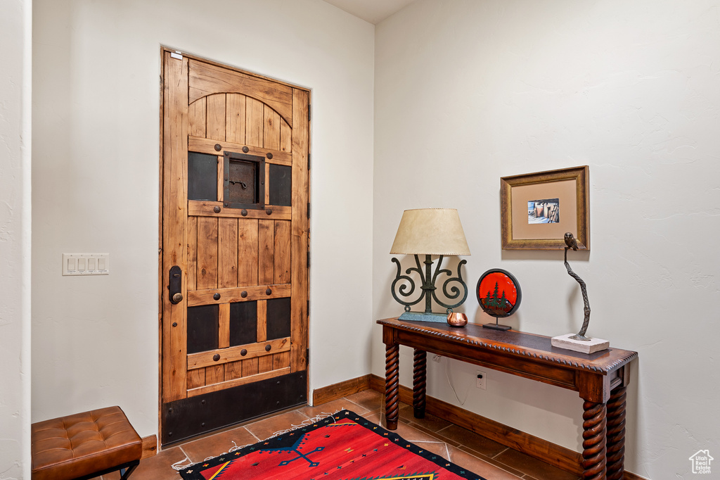 Tiled foyer entrance with baseboards