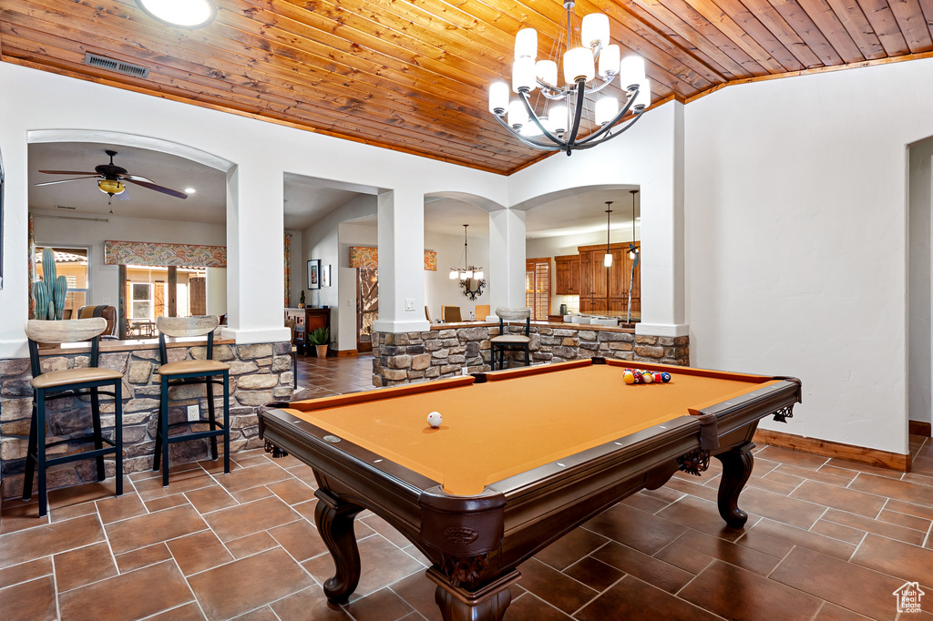 Rec room with arched walkways, ceiling fan with notable chandelier, lofted ceiling, visible vents, and wood ceiling