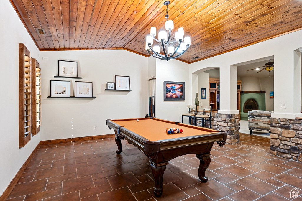 Recreation room with wooden ceiling, arched walkways, ornamental molding, and ceiling fan with notable chandelier