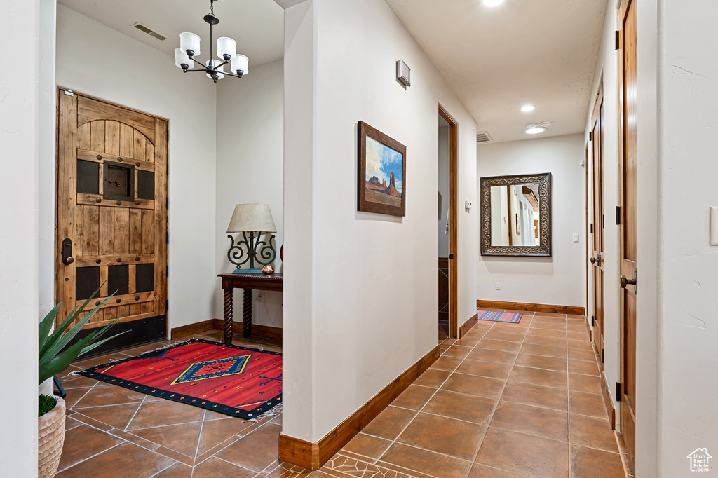 Corridor with baseboards, tile patterned flooring, and visible vents