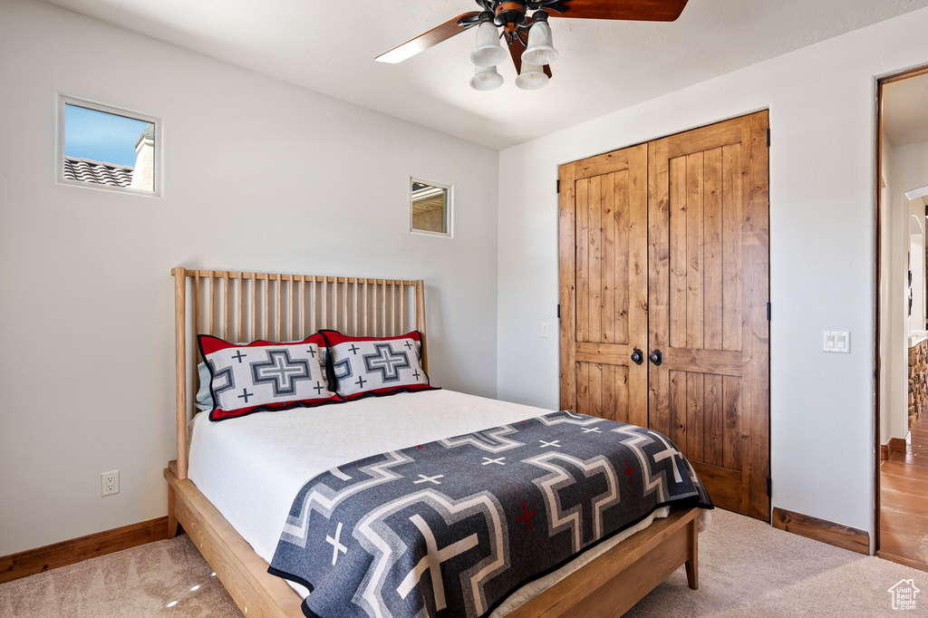 Bedroom with baseboards, carpet flooring, a ceiling fan, and a closet