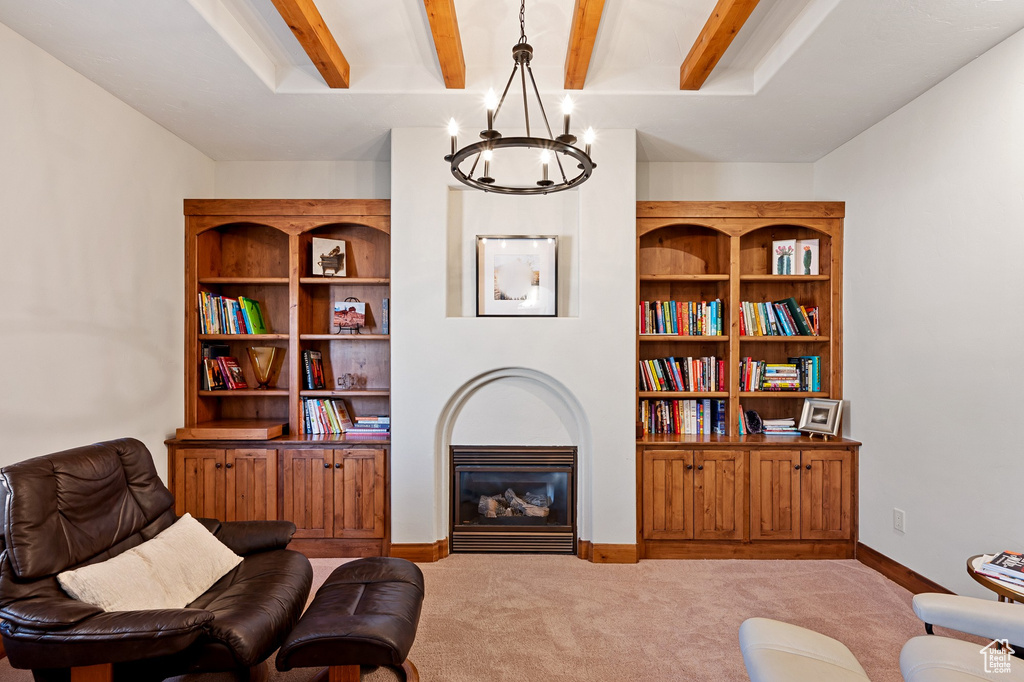 Sitting room featuring baseboards, carpet, a notable chandelier, and beamed ceiling