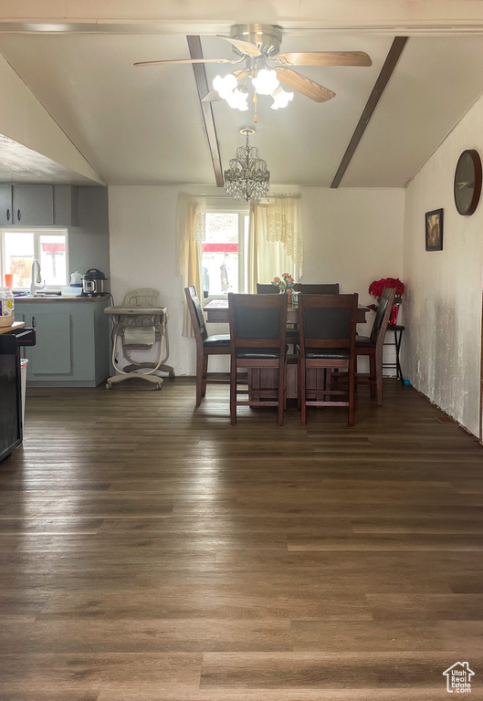 Dining area featuring vaulted ceiling, ceiling fan with notable chandelier, wood finished floors, and a healthy amount of sunlight