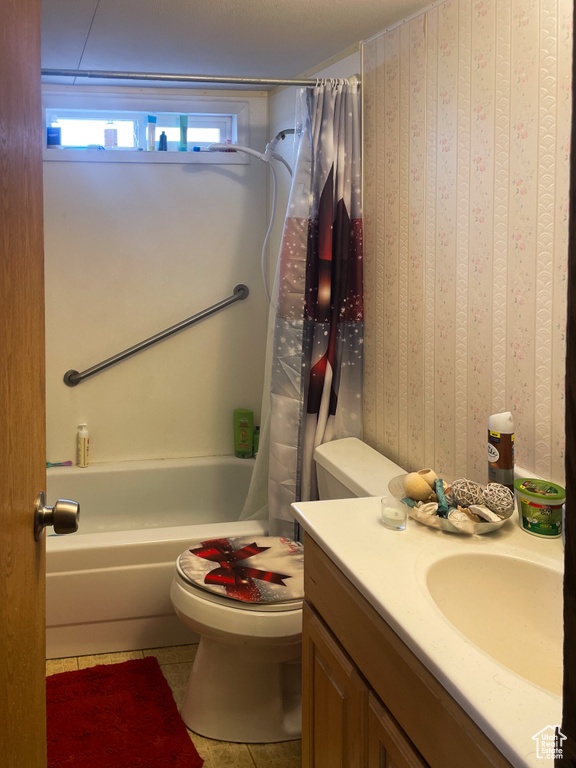 Bathroom with shower / bath combo with shower curtain, vanity, toilet, and tile patterned floors