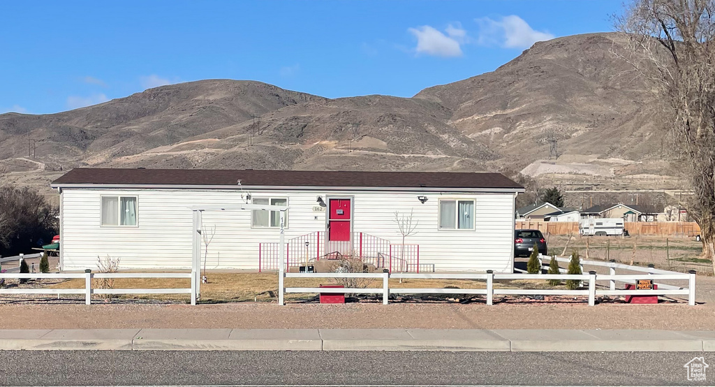 View of front of home featuring a fenced front yard and a mountain view