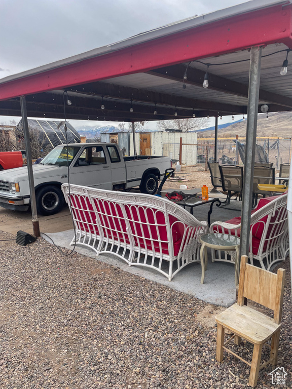 View of parking featuring fence and a carport