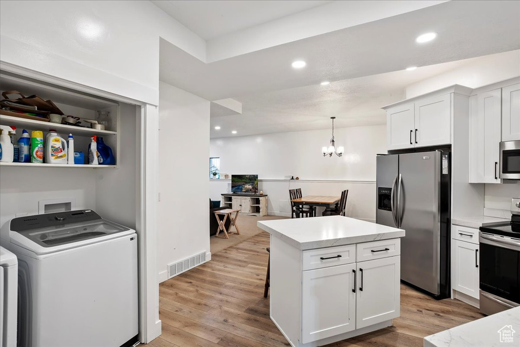 Kitchen featuring light wood-style floors, visible vents, washer / clothes dryer, and stainless steel appliances