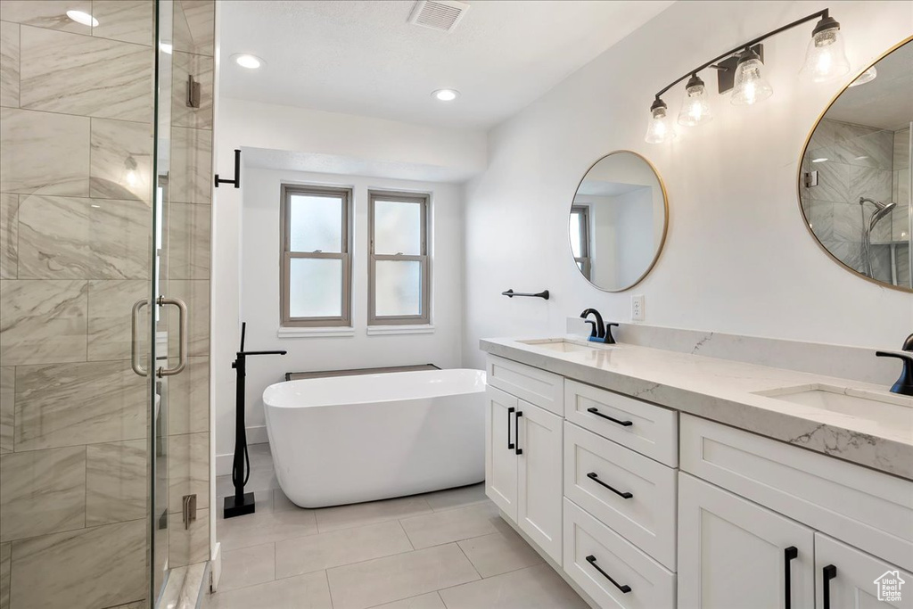 Full bathroom featuring double vanity, a sink, visible vents, and a shower stall