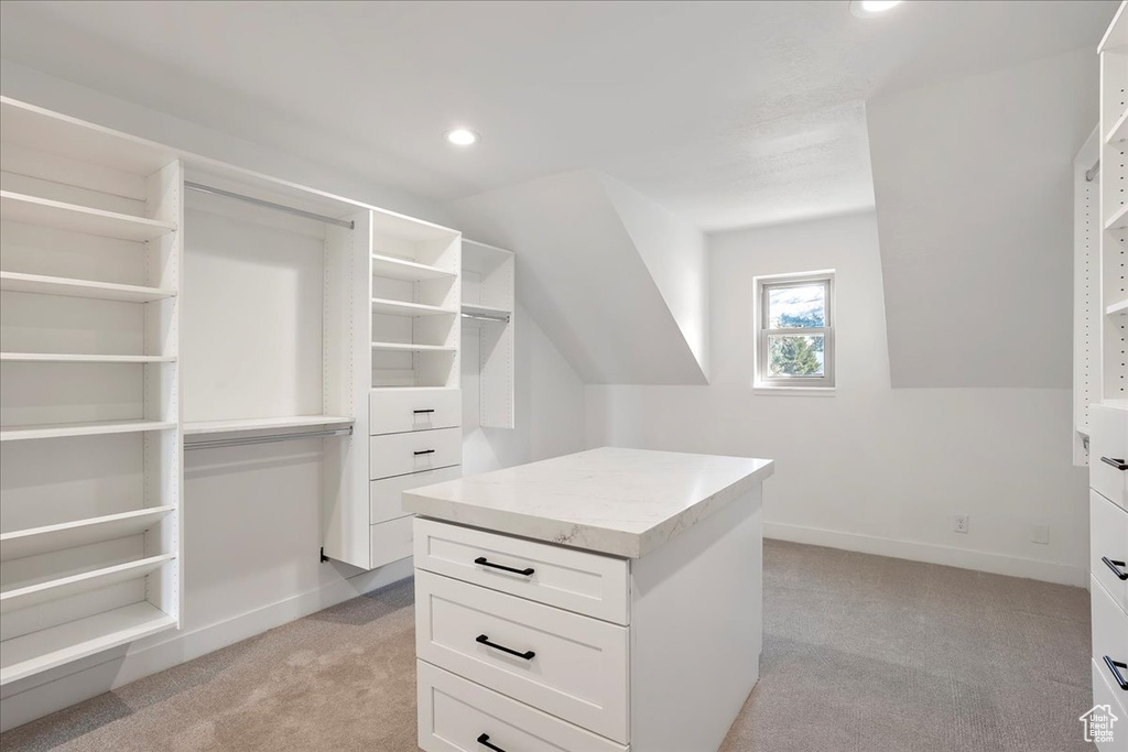 Walk in closet with light colored carpet