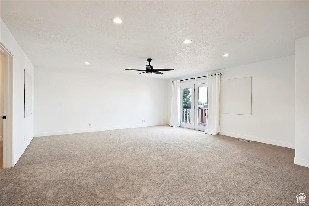 Carpeted empty room with recessed lighting, a textured ceiling, and baseboards