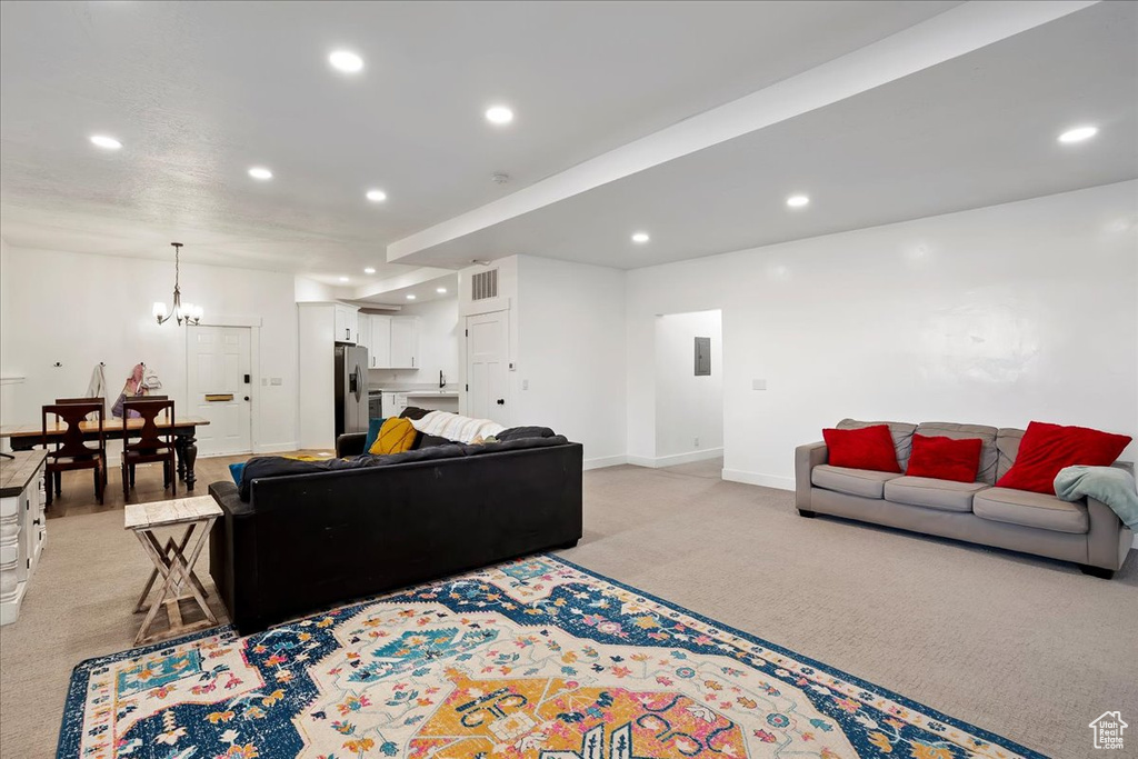 Living area featuring light carpet, baseboards, and recessed lighting