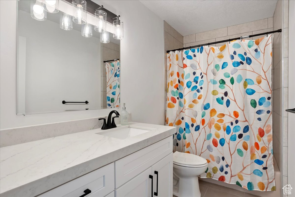 Full bathroom with tile patterned flooring, a shower with shower curtain, vanity, and toilet