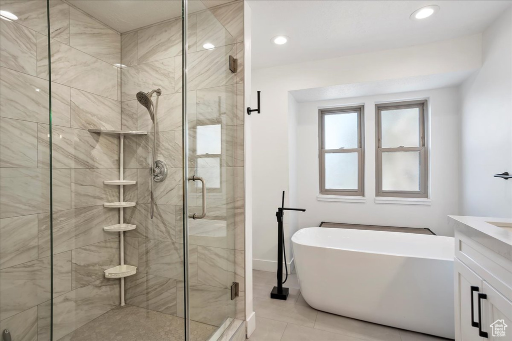 Bathroom with a soaking tub, a shower stall, vanity, and recessed lighting