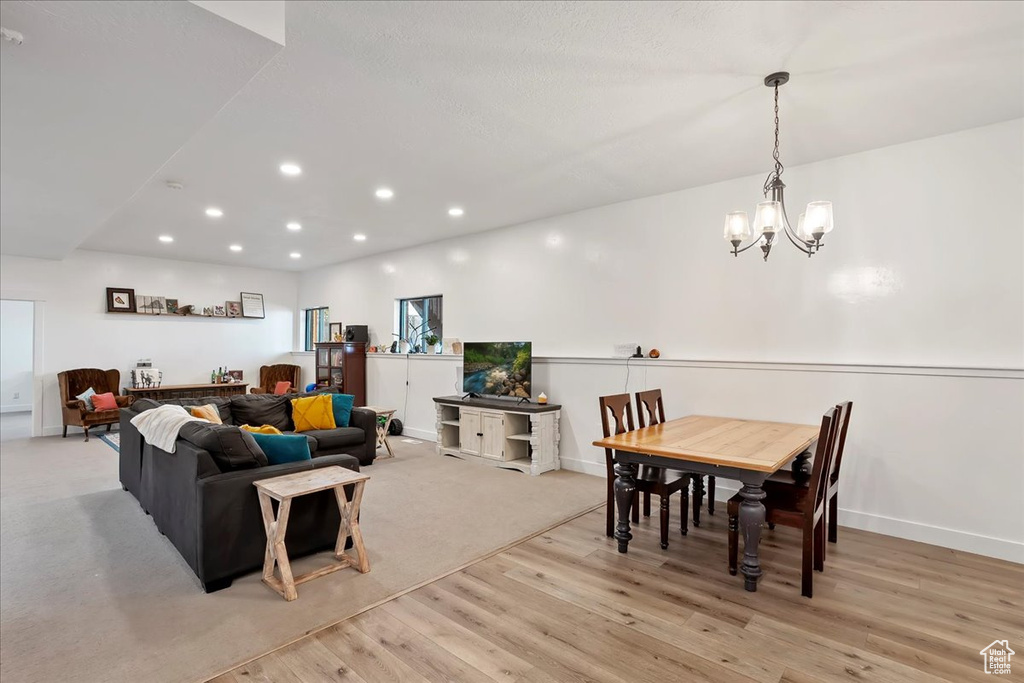 Living area with light wood-style floors, baseboards, a chandelier, and recessed lighting