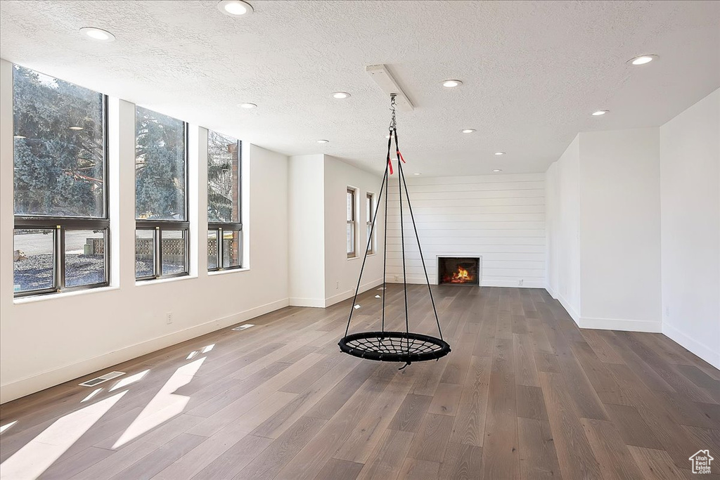 Workout room featuring recessed lighting, visible vents, a large fireplace, a textured ceiling, and wood finished floors