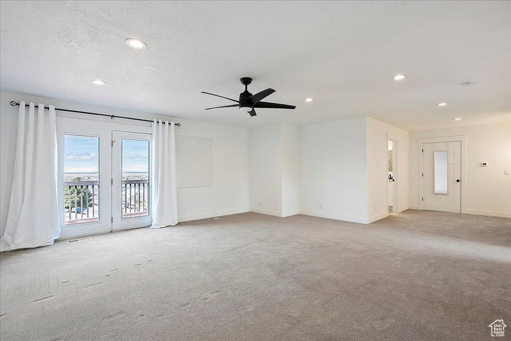Carpeted empty room featuring a textured ceiling, baseboards, a ceiling fan, and recessed lighting