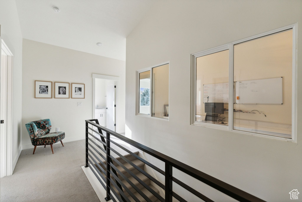 Hall with carpet floors and an upstairs landing