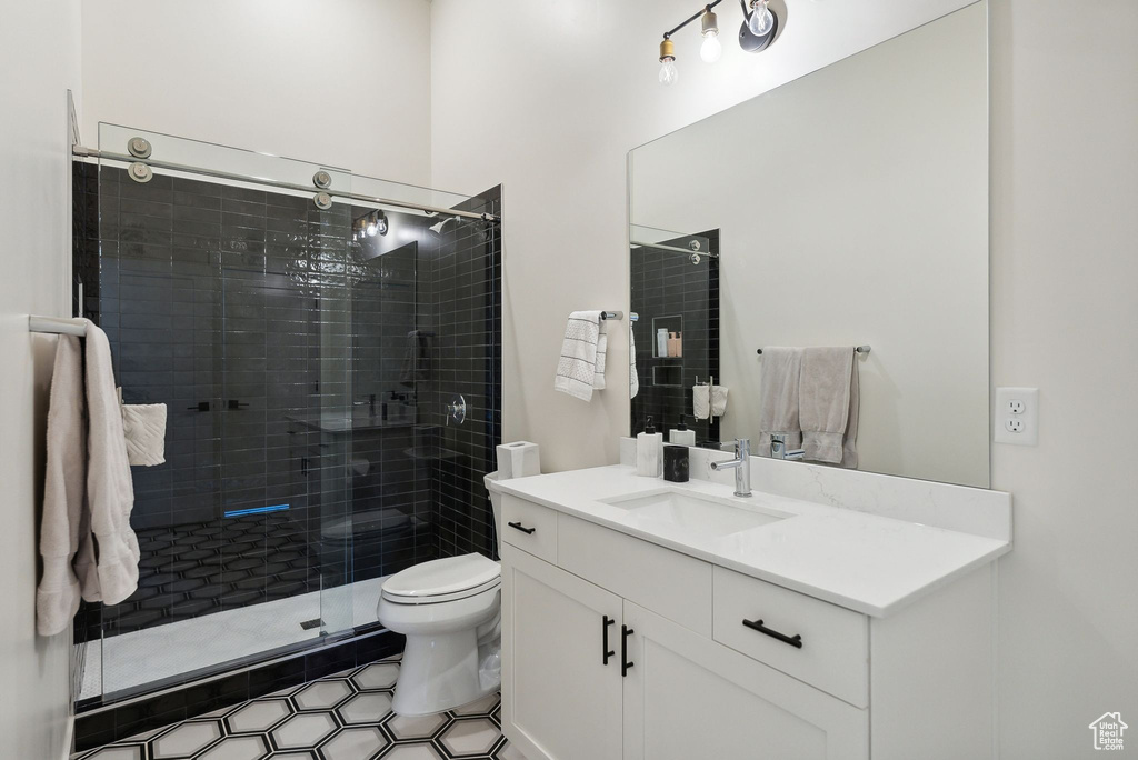 Bathroom with toilet, a shower stall, and vanity