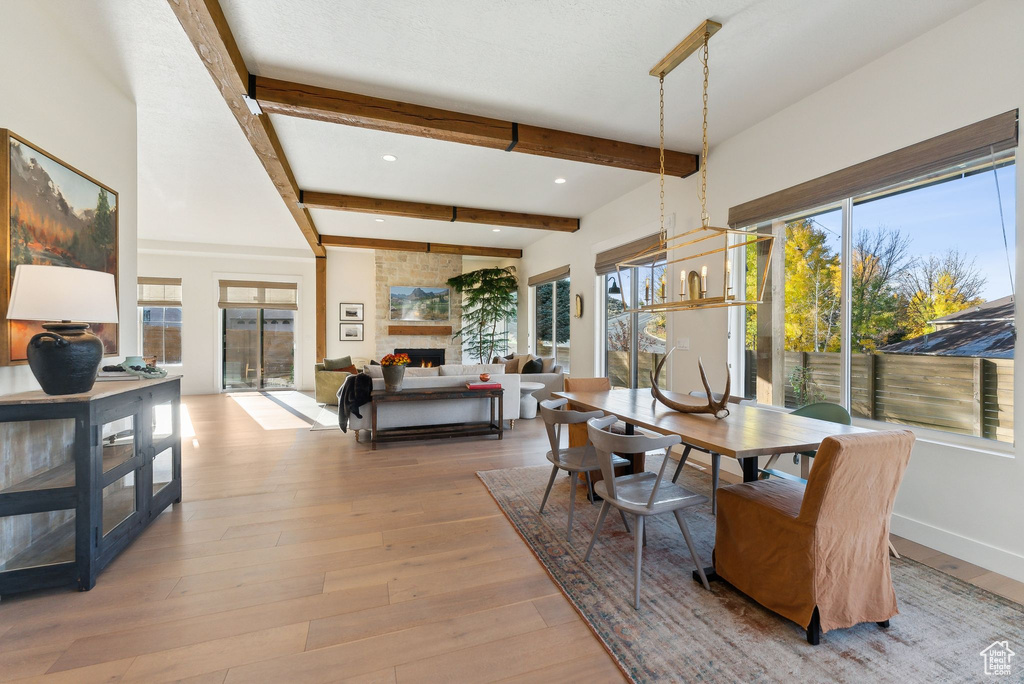 Dining space with baseboards, hardwood / wood-style flooring, beamed ceiling, a fireplace, and recessed lighting