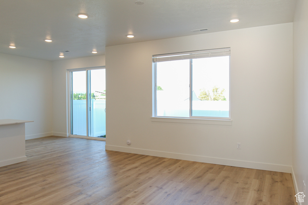 Spare room featuring light wood-style floors, visible vents, and baseboards