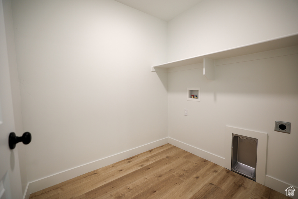 Laundry room with laundry area, baseboards, light wood-style flooring, hookup for a washing machine, and electric dryer hookup