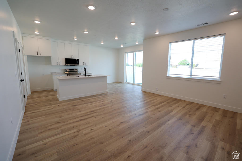 Kitchen with visible vents, appliances with stainless steel finishes, light wood-style flooring, and recessed lighting