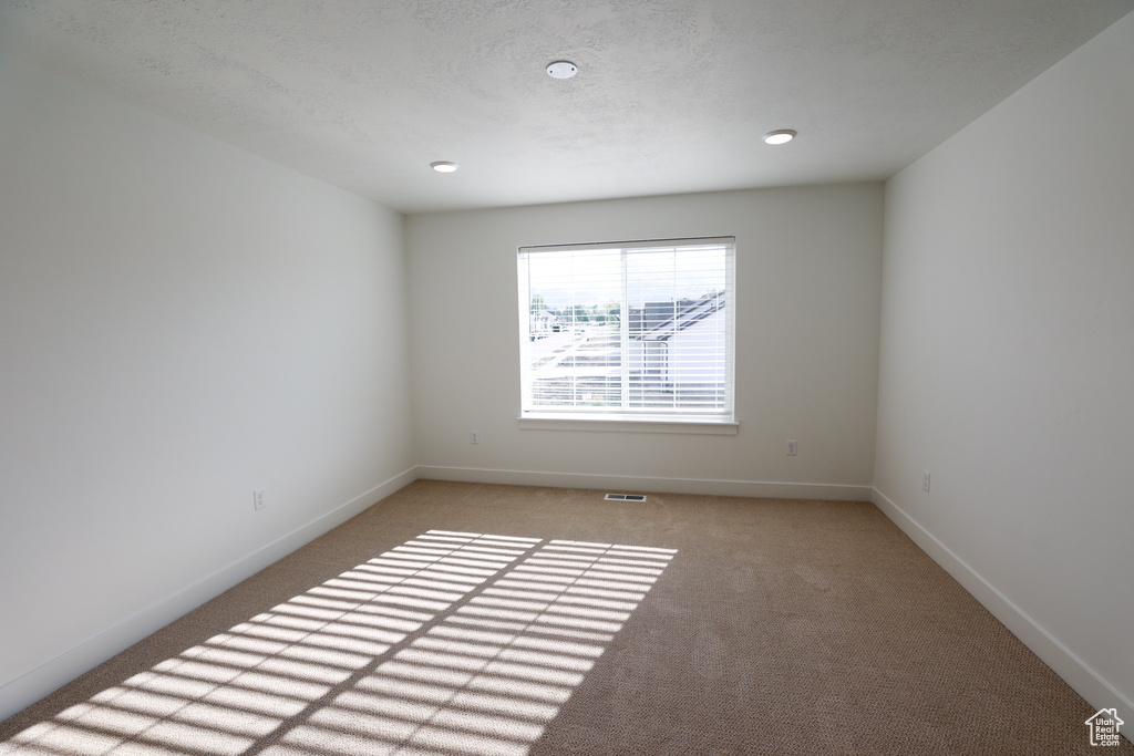 Unfurnished room featuring light colored carpet and baseboards