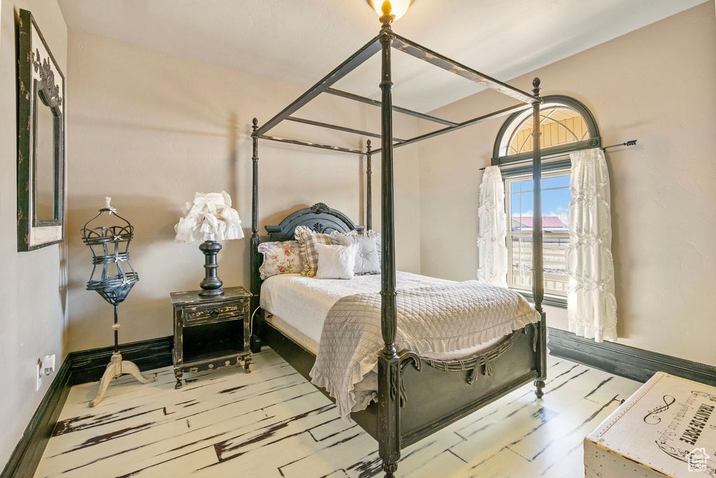 Bedroom with wood finished floors and baseboards