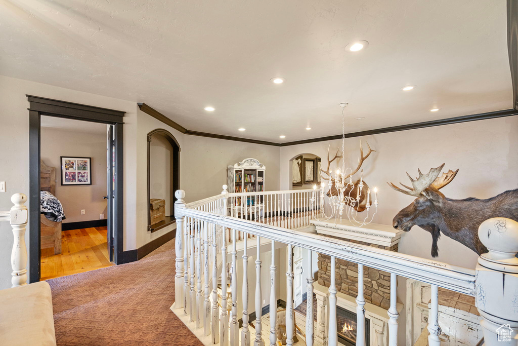 Hall with recessed lighting, a chandelier, arched walkways, and ornamental molding