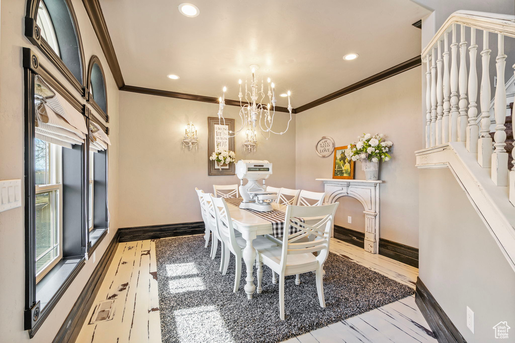 Dining area featuring baseboards, hardwood / wood-style flooring, ornamental molding, a chandelier, and recessed lighting