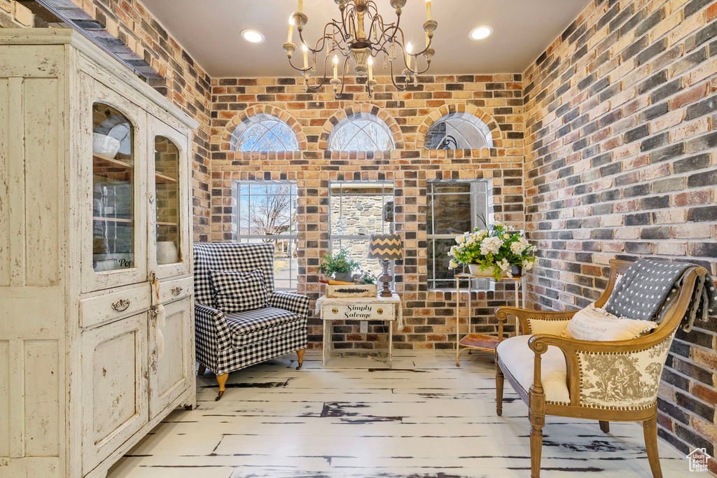 Sitting room with a notable chandelier and brick wall